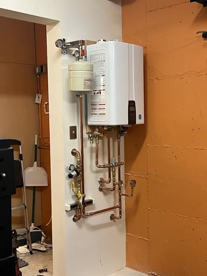 Plumbing technician inspecting water heater connections in Folkston